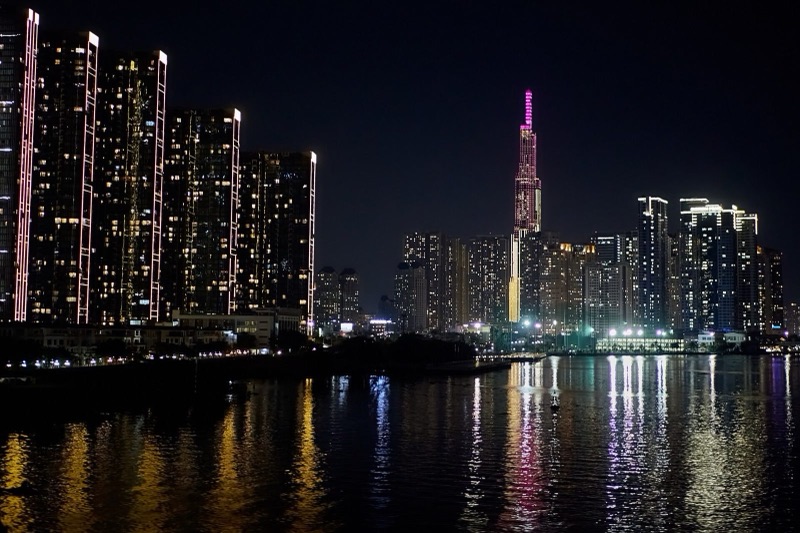 Landmark 81 và dãy cao ốc ven sông Sài Gòn về đêm, ánh đèn phản chiếu xuống mặt nước