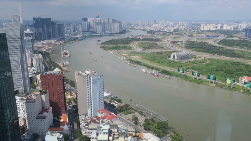 Sông Sài Gòn uốn quanh bán đảo Thủ Thiêm nhìn từ trên cao, bên trái là các tòa nhà Quận 1, bên phải là bán đảo Thủ Thiêm còn nhiều bãi cỏ trống